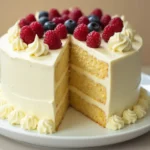 Delicious white chocolate cake with a smooth white chocolate ganache drip and decorative white chocolate shavings.